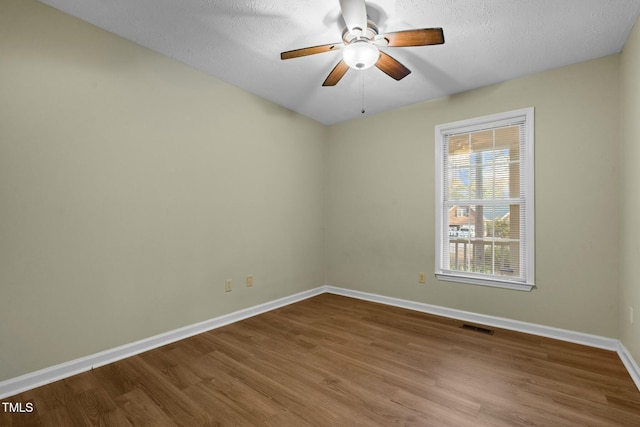 spare room with ceiling fan, hardwood / wood-style floors, and a textured ceiling