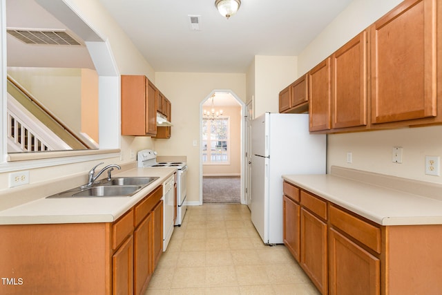 kitchen with a chandelier, white appliances, and sink