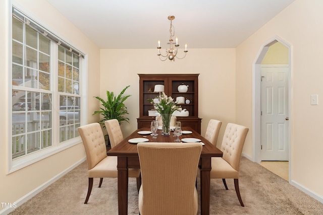 2124 Star Sapphire Dr, Raleigh, NC 27610 - dining space with light colored carpet, a chandelier, and baseboards