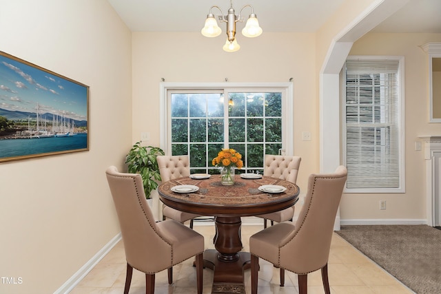 tiled dining room with an inviting chandelier