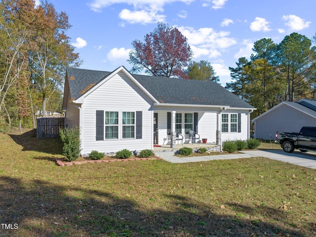 ranch-style home featuring covered porch and a front lawn