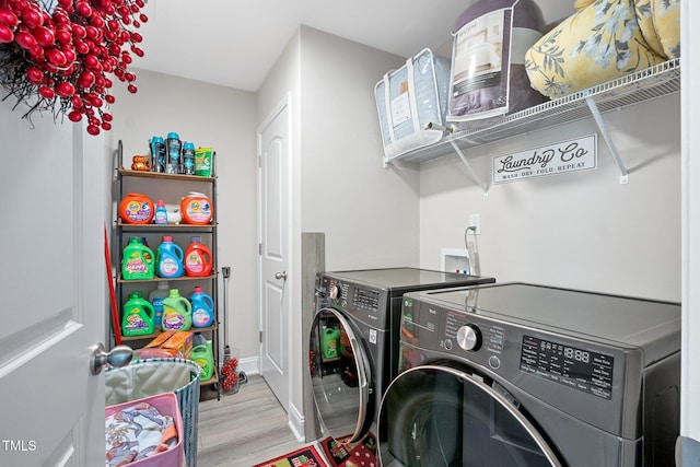 clothes washing area with light wood-type flooring and washer and clothes dryer