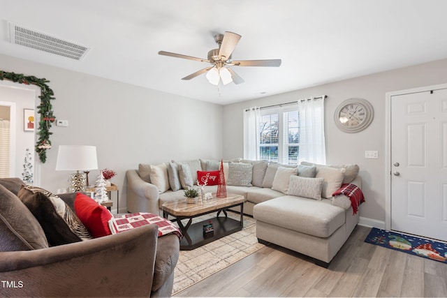 living room with light hardwood / wood-style flooring and ceiling fan