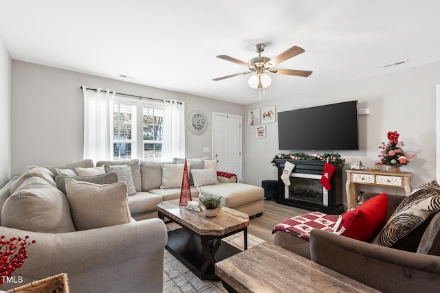 living room featuring ceiling fan and light hardwood / wood-style floors