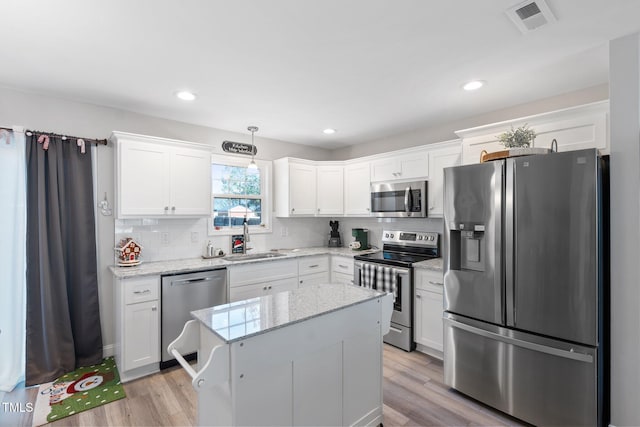 kitchen with white cabinetry, sink, a kitchen island, and appliances with stainless steel finishes