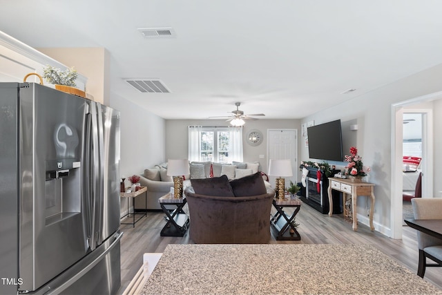 living room with ceiling fan and light hardwood / wood-style flooring