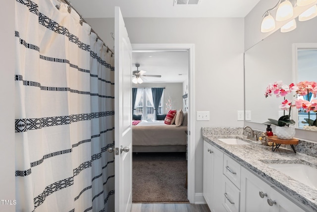 bathroom featuring wood-type flooring, vanity, and ceiling fan