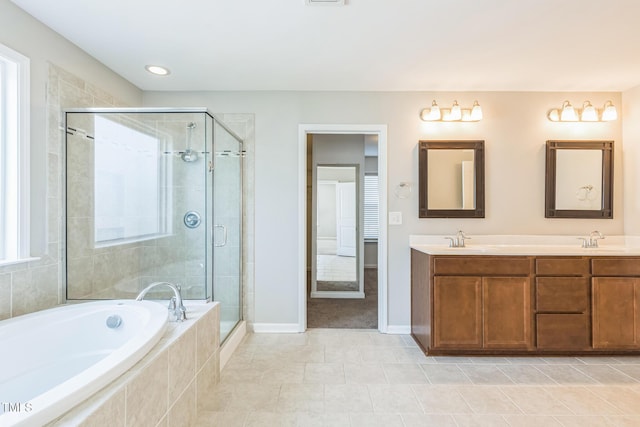 bathroom with tile patterned floors, vanity, and shower with separate bathtub