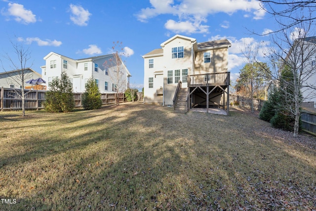 rear view of property featuring a yard and a wooden deck