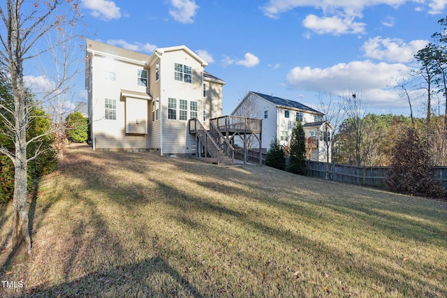 back of property featuring a lawn and a wooden deck