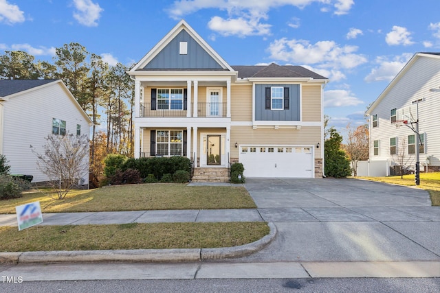 craftsman-style house with a balcony, a front yard, and a garage