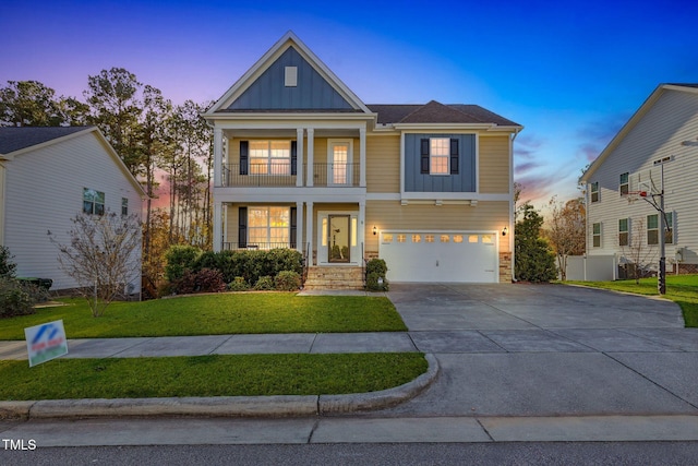 craftsman-style home featuring a lawn, a balcony, and a garage