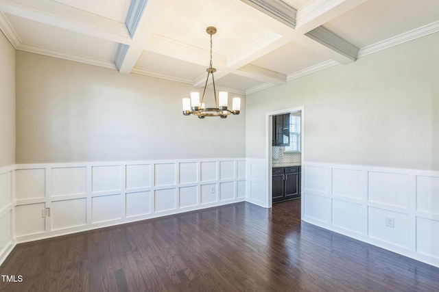 empty room featuring crown molding, a chandelier, and dark hardwood / wood-style floors