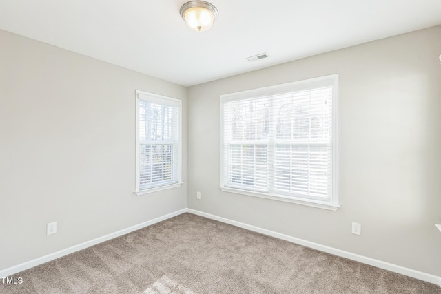 carpeted spare room featuring a wealth of natural light