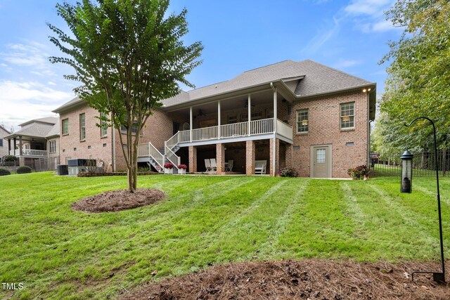 rear view of property featuring a lawn, ceiling fan, and central air condition unit