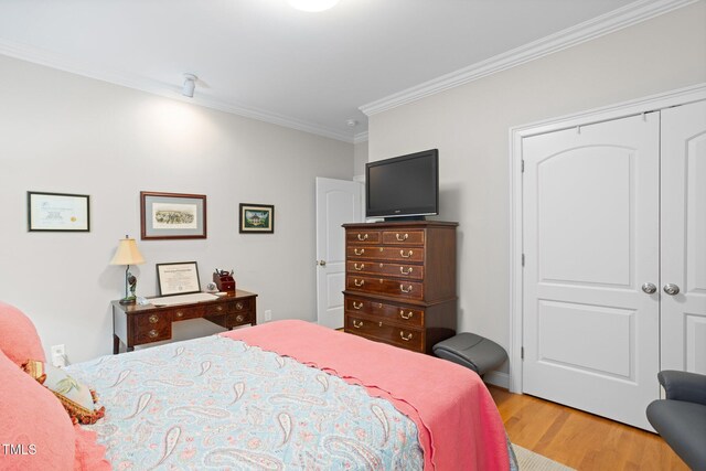 bedroom with ornamental molding, light hardwood / wood-style flooring, and a closet