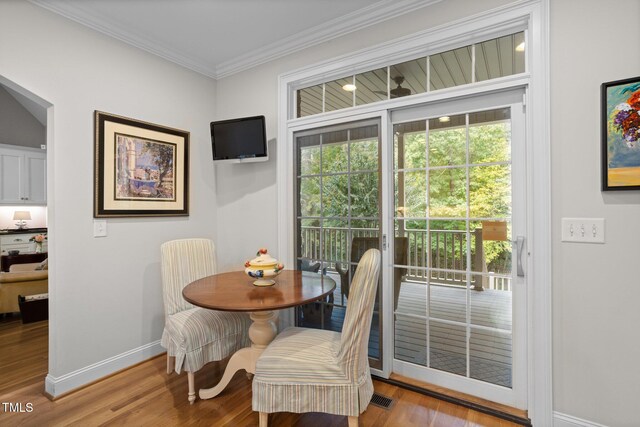 dining room with wood-type flooring and ornamental molding