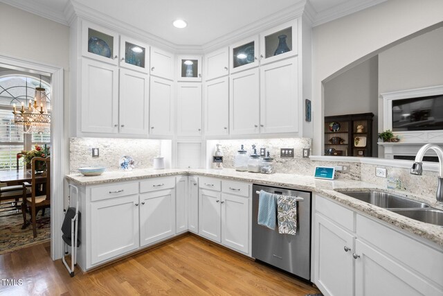 kitchen with stainless steel dishwasher, white cabinetry, sink, and light hardwood / wood-style flooring