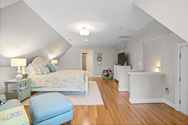 bedroom featuring light hardwood / wood-style flooring and lofted ceiling