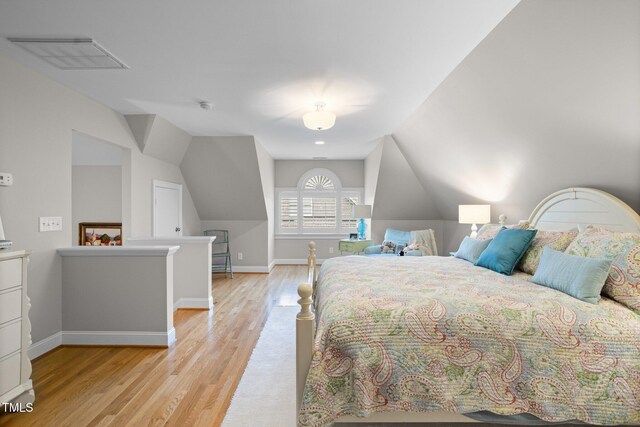 bedroom featuring light wood-type flooring and lofted ceiling