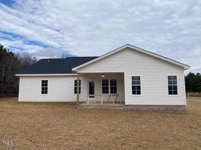 back of house with a patio and a lawn