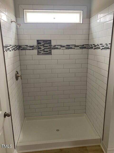 bathroom with tiled shower