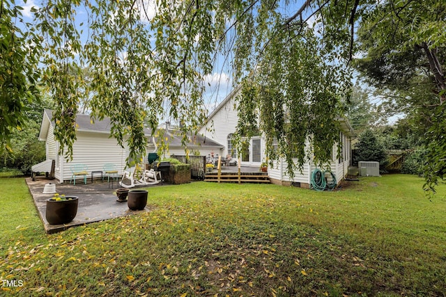 view of yard featuring a patio, central AC unit, and a wooden deck