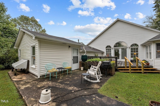 back of property featuring a yard and a wooden deck