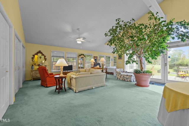 carpeted living room with ceiling fan, plenty of natural light, and vaulted ceiling