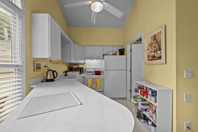 kitchen with white appliances, vaulted ceiling, ceiling fan, sink, and white cabinets