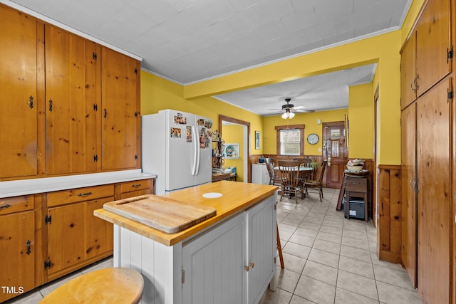 kitchen featuring ceiling fan, light tile patterned flooring, ornamental molding, and white refrigerator