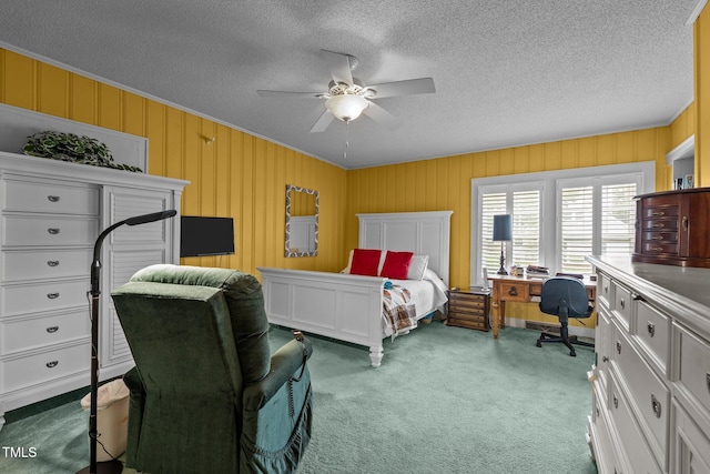 carpeted bedroom featuring a textured ceiling, ceiling fan, and wooden walls