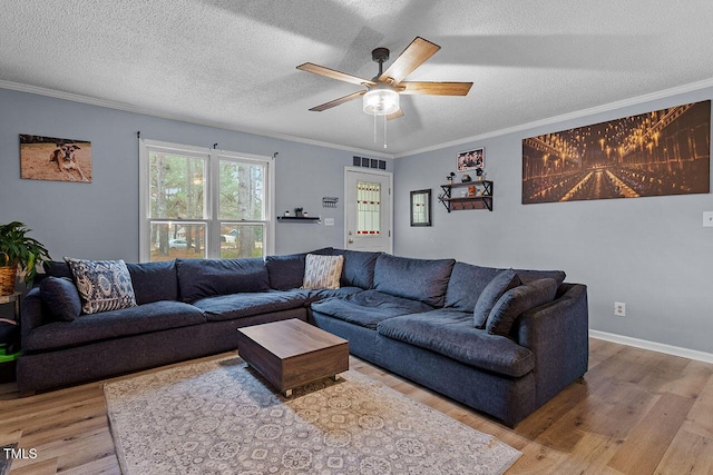 living room with a textured ceiling, ceiling fan, light wood-type flooring, and ornamental molding