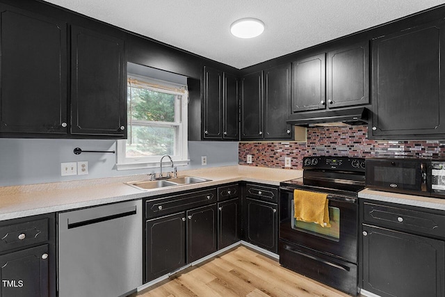 kitchen with sink, light hardwood / wood-style floors, backsplash, and black appliances