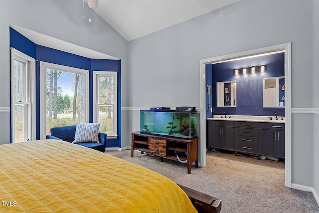 carpeted bedroom with connected bathroom, ceiling fan, lofted ceiling, and sink