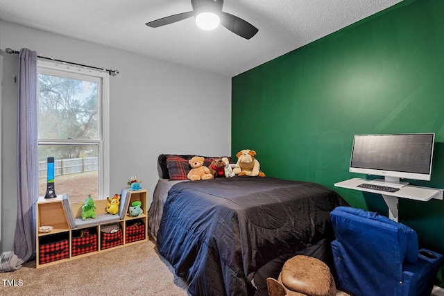 carpeted bedroom with ceiling fan and a textured ceiling