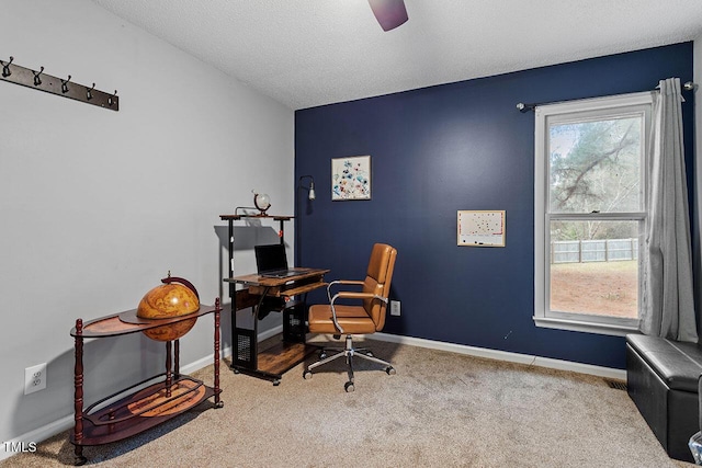 carpeted office space featuring ceiling fan and a textured ceiling