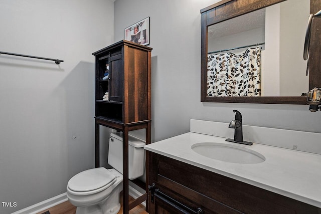 bathroom with hardwood / wood-style floors, vanity, and toilet