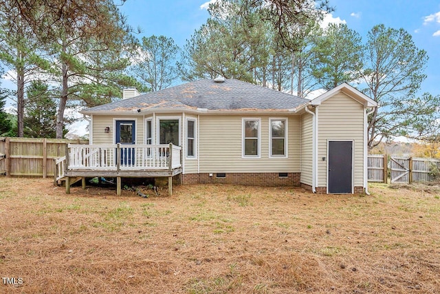 rear view of house featuring a lawn and a deck