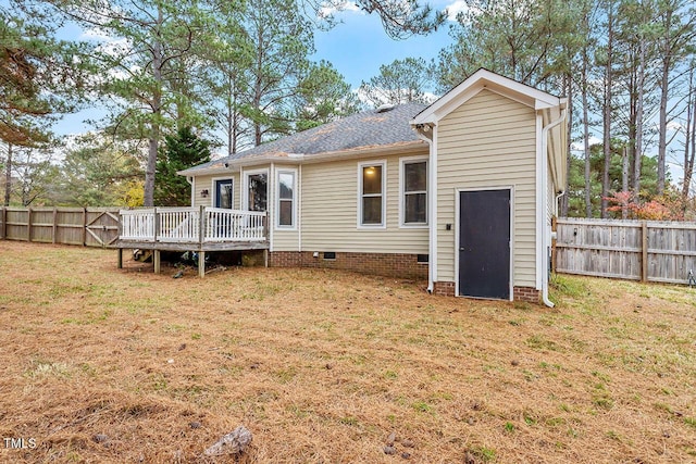 rear view of house with a lawn and a wooden deck