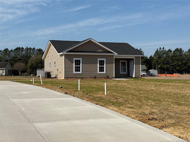 view of front of property with a shingled roof and a front lawn