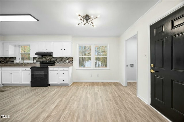 kitchen featuring light hardwood / wood-style flooring, black electric range, ornamental molding, tasteful backsplash, and white cabinetry