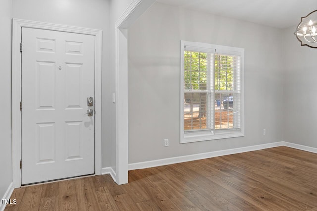 foyer featuring hardwood / wood-style flooring and an inviting chandelier