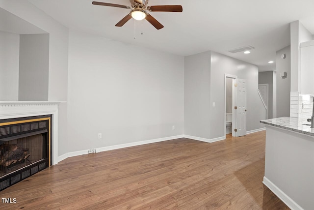 unfurnished living room featuring ceiling fan and light hardwood / wood-style floors