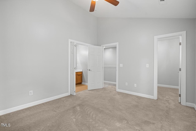 unfurnished bedroom featuring ceiling fan, connected bathroom, light colored carpet, and high vaulted ceiling