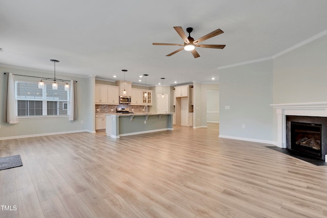 unfurnished living room featuring crown molding, ceiling fan with notable chandelier, and light wood-type flooring