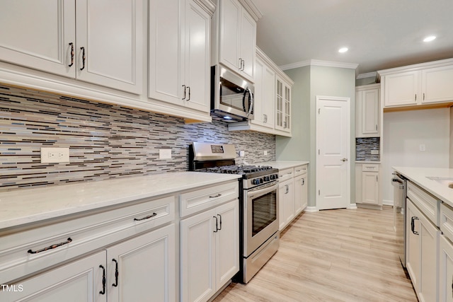 kitchen featuring tasteful backsplash, white cabinetry, and appliances with stainless steel finishes