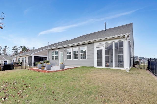 rear view of property with a sunroom, a patio area, and a yard