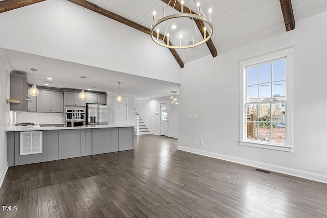 unfurnished living room featuring beam ceiling, dark hardwood / wood-style flooring, high vaulted ceiling, and an inviting chandelier