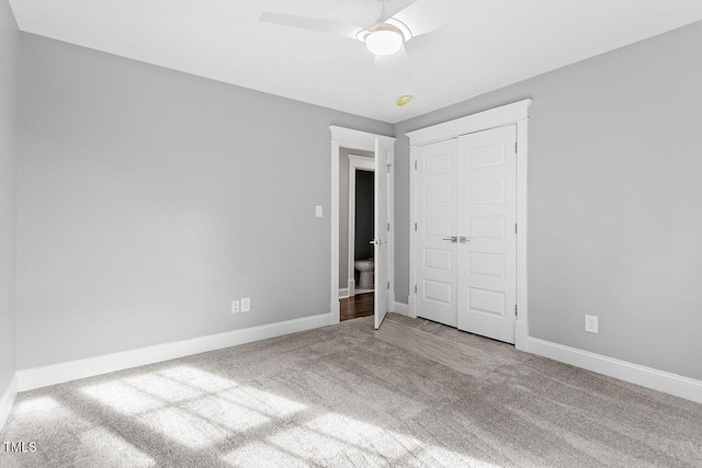 unfurnished bedroom featuring ceiling fan, a closet, and carpet